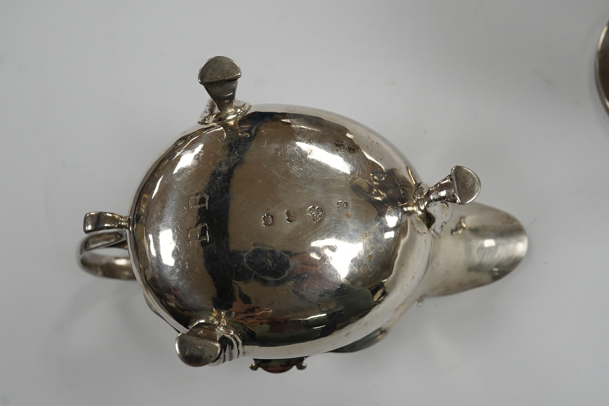A George II small silver sauceboat, Gwillim & Castle, London, 1744, length 13.6cm, together with a George III silver hot water jug, London, 1791, gross 9.6oz. Condition - poor